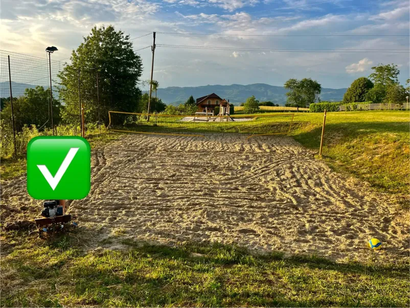 Bager izkopava in razkłada pesek Velik rumen bager izkopava in raztovarja pesek na gradbišču. Z masivno žlico premika material, medtem ko se dviguje rahel prah.