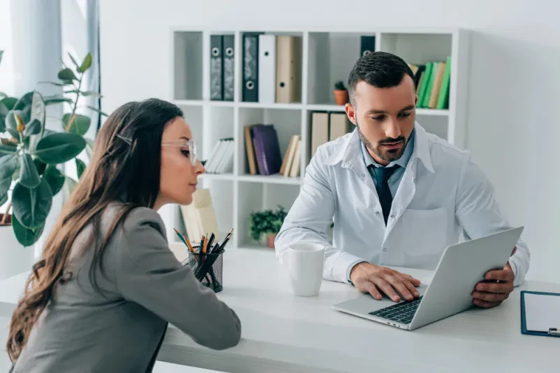 Doktor išče informacije na računalniku za pacientko