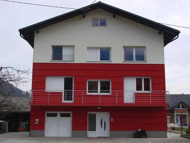 Nova fasada na večstanovanjskem objektu, v beli in rdeči kombinaciji barve.