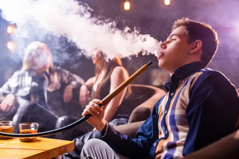 Vodna pipa je postavljena na mizo v prijetno osvetljenem lounge baru v Ljubljani.