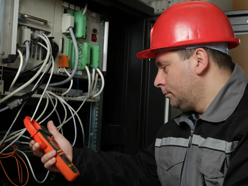 Strokovnjak za električne inštalacije izvaja meritev električnega toka in napeljave na Dolenjskem.