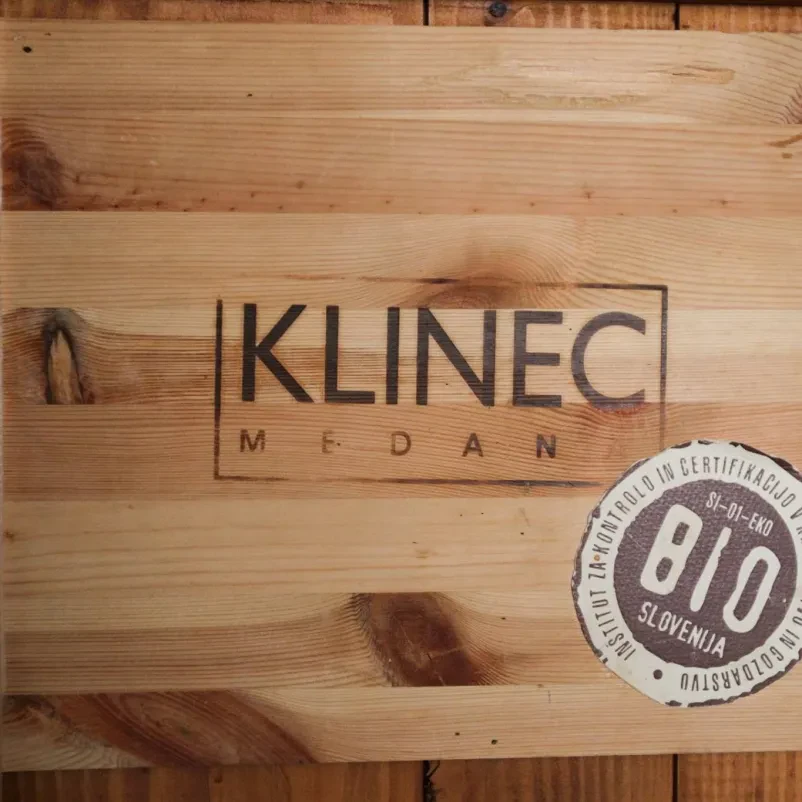 Deska za rezanje, na kateri je odtisnjen logotip kmetije Klinec.