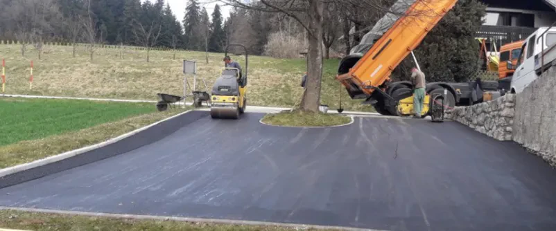 Kamion stresa asfalt na pripravljeno površino za asfaltiranje v Osrednji Sloveniji.