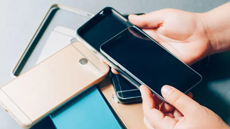 Popravilo pokvarjenega mobilnega telefona, na mizi so rezervni deli za mobitel.