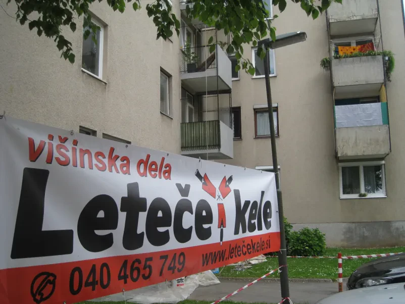 Pano podjetja Leteče kele, obešen pred objektov, kjer izvajajo sanacijska dela v Ljubljani.