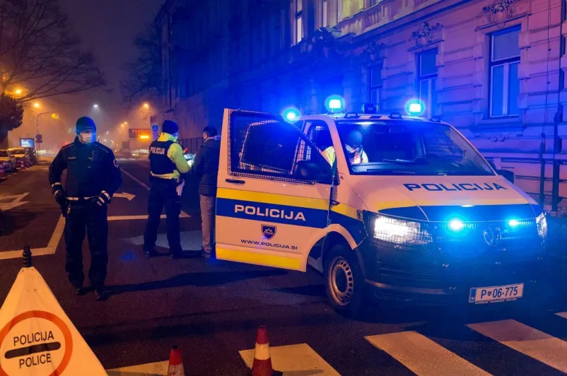 Policijski kombi in policija v temni ulici