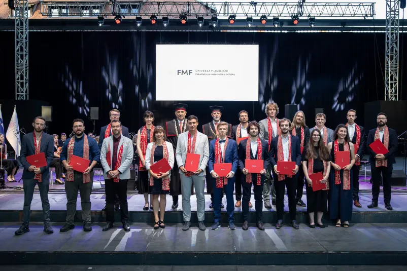 Podelitev diplom študentom FMF, ki so diplomirali na smeri fizika. Diplomantje stojijo na odru.