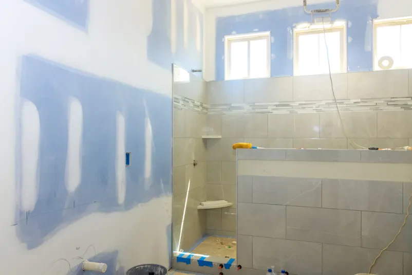 Kopalnica, v kateri je keramičar odstranil stare ploščice in v okviru prenove polaga novo keramiko.