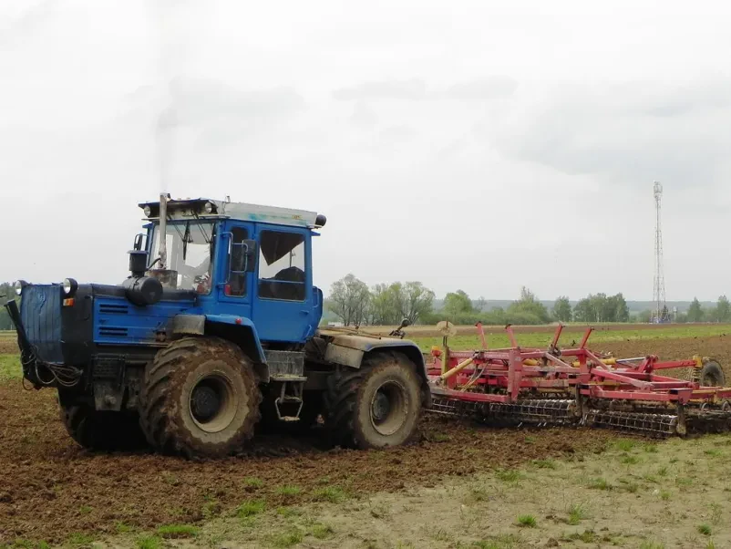 Moder traktor pluži zemljo