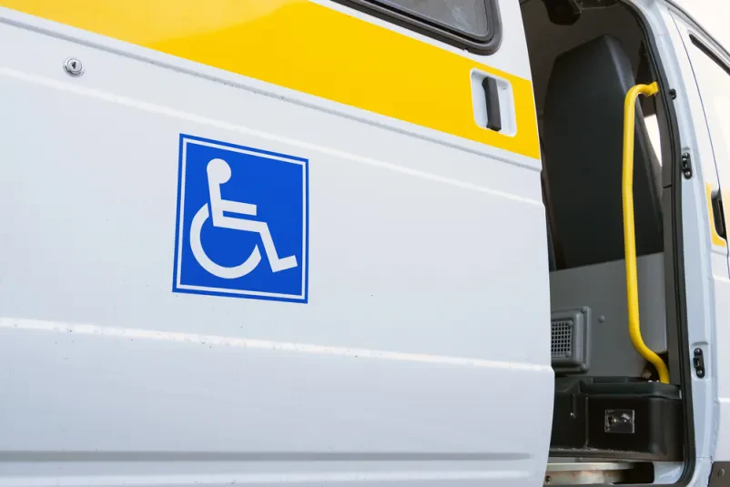 Moški na invalidskem vozičku na avto dvigalu Zanesljivi prevozi invalidnih oseb Trojane