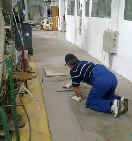 Natančna izvedba zaokrožnic med steno in tlemi, ki zagotavlja higienične in odporne industrijske tlake.