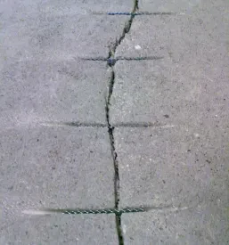Pogled od blizu na sanacijo razpok v betonu pred nanosom zaščitnega premaza, za dolgotrajne kvalitetni epoksi tlaki Slovenija.