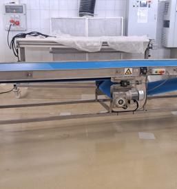 Detajlen posnetek večpasovnega transportnega sistema, zgrajenega iz kakovostnih inox konstrukcij, ki je ključnega pomena za optimizacijo logistike.