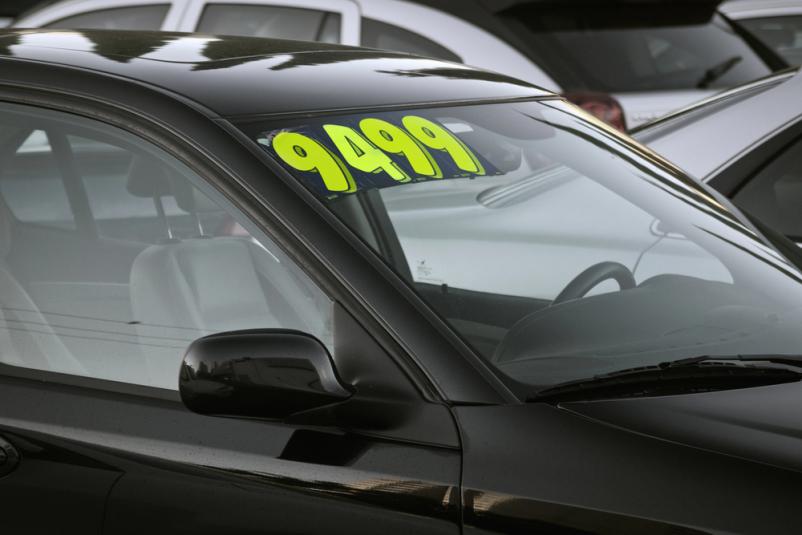 Rabljeno vozilo z oznako 'Naprodaj' Beli avtomobil z oznako