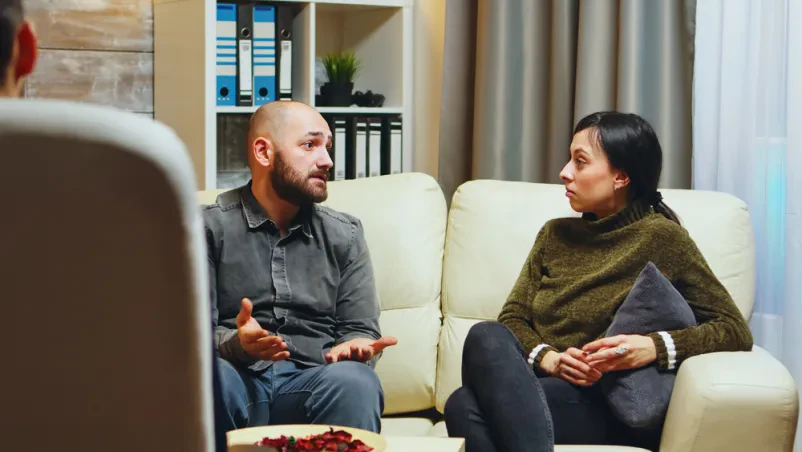 Moški izraža nezadovoljstvo Mladenič pred terapevtko izraža nezadovoljstvo svoji ženi. Prikazan je iskren, a napet pogovor o njunih izzivih.