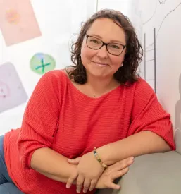 Ajda Strnad vodi delavnico za dva mladostnika, ki pozorno poslušata in sodelujeta v skupinski razpravi o izzivih.