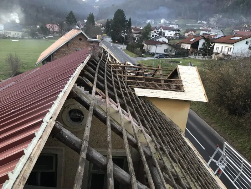 Dviganje strešnikov na streho hiše HIAB dvigalo dviguje strešnike na streho, kar poudarja storitve s HIAB dvigalom in kiper prevozi Ljubljana okolica Dolenjska.