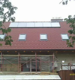 Tovornjak s HIAB dvigalom, ki z roko manipulira z lesom na gradbišču, kar omogoča enostavno urejanje in prevoz tovora.