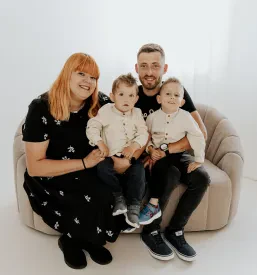 Ženska, ki se nasmiha v objektivu med profesionalnim fotografiranjem, poudarja naravne izraze in studio fotografijo.