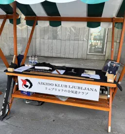 Skupinska fotografija prikazuje otroke in odrasle člane aikido kluba. Treningi aikida Ljubljana združujejo generacije in spodbujajo razvoj veščin.