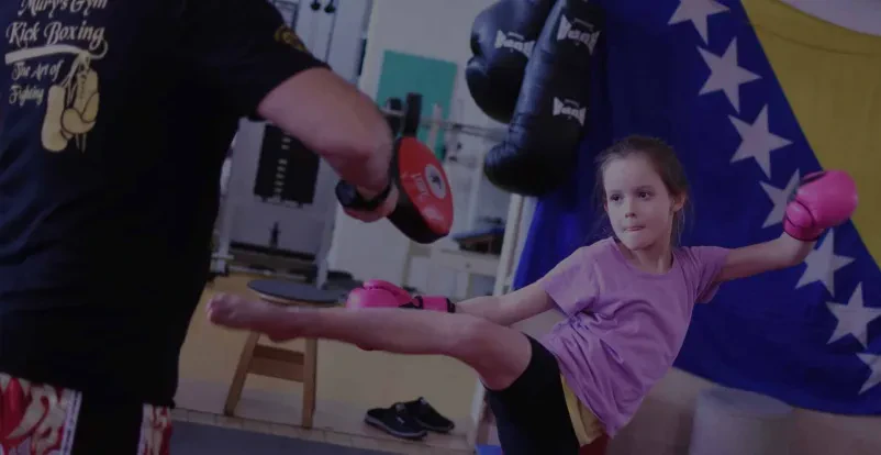 Trening borilnih veščin za otroke Skupina otrok med aktivnim treningom borilnih veščin, kjer se učijo discipline in gibanja v zabavnem okolju.