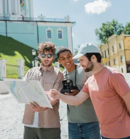 Bradati turist kaže na zemljevidu blizu vodiča. To je del turističnega vodenja v tujih jezikih Slovenija.
