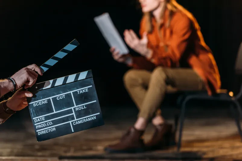 Igralec s klapo na filmskem setu Moški igralec drži filmsko klapo, pripravljen za začetek prizora. Išče se dober igralec za reklame, serije in filme v Sloveniji.