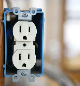 Namestitev električne vtičnice na lesen steber v novogradnji prikazuje ključni del kvalitetne montaže elektroinštalacij v Ljubljani.