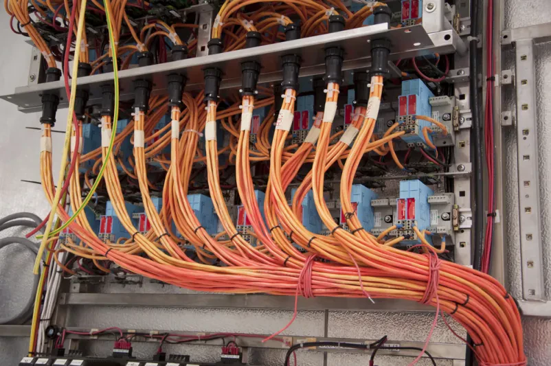Nadzorna plošča z industrijsko napeljavo Nadzorna plošča z električno napeljavo, bistvena za krmiljenje sistemov v industrijskih objektih in proizvodnih linijah.