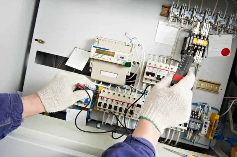 Električar meri napetost z multimetrom Električar z multimetrom natančno meri visoko napetost v plošči, nujno za kvalitetne elektroinštalacije Nova Gorica, Goriška.