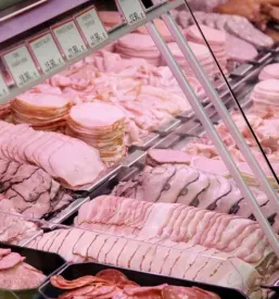Pregleden pult s široko ponudbo narezanih delikatesnih mesnin, kar poudarja Kvalitetne mesne izdelke Brezovica, Osrednja Slovenija.