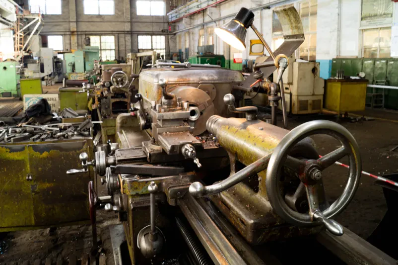 Detajl krmilnih ročic in gumbov na industrijskem stroju, ki omogoča precizno obdelavo kovin v proizvodnem obratu.