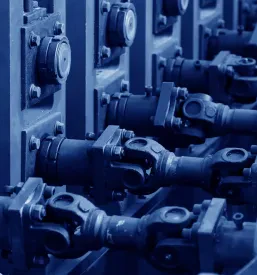Bližnji posnetek delujočega rotacijskega mehanizma z rdečimi in črnimi komponentami, ki je bistven del industrijske opreme in vzdrževanja v tovarniškem okolju.