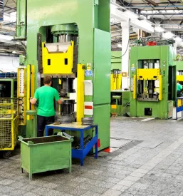 Notranjost tovarne prikazuje vrsto težkih industrijskih strojev, ki so namenjeni za učinkovito predelavo kovin in izdelavo polizdelkov.