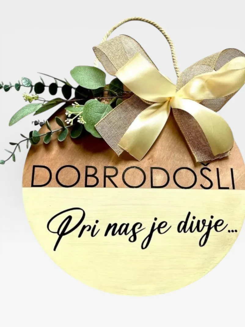 Lesena okrasna tabla z dinozavrom Okrasna lesena tabla z motivom dinozavra in imenom otroka, narejena po meri. Personalizirani leseni izdelki Obala nudijo unikatna darila.