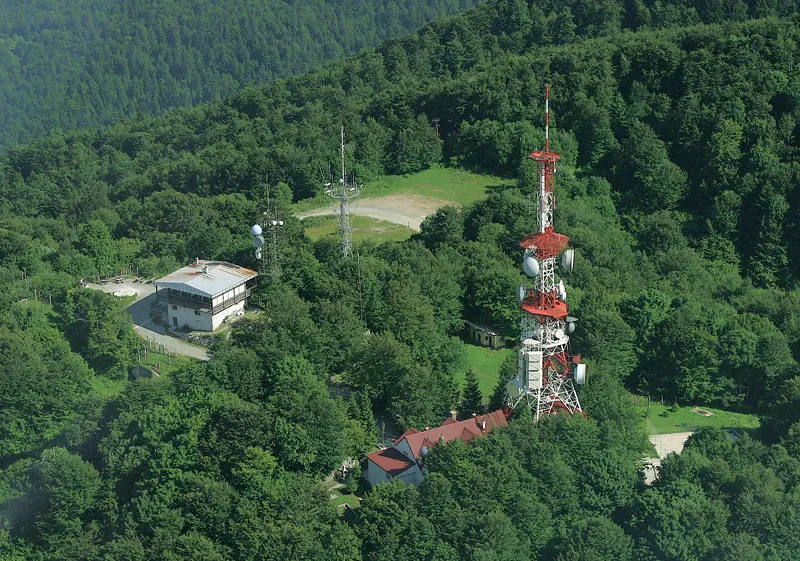 Urejena notranjost jedilnice Planinskega doma Ig Ljubljana, pripravljena za postrežbo domačih jedi in pijače, kjer se gostje lahko ogrejejo.