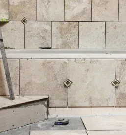 Moderna in funkcionalna kopalnica z elegantnimi keramičnimi ploščicami, stekleno tuš kabino in sodobno sanitarno opremo.