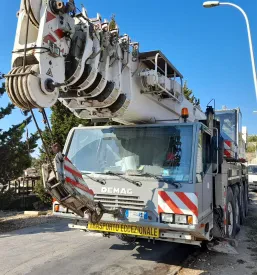 Avtodvigalo Demag AC 80-2 stoji na industrijskem dvorišču. Prodaja najem škarjaste in teleskopske dvižne ploščadi Ljubljana.