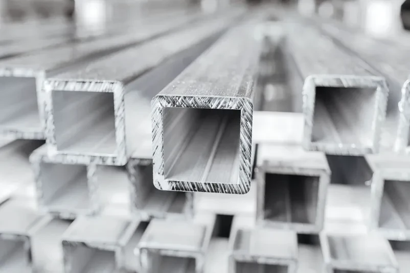 Delavec pri delu na stroju za obdelavo kovin Aluminij med obdelavo na industrijskem stroju, zagotavljajoč kakovost.