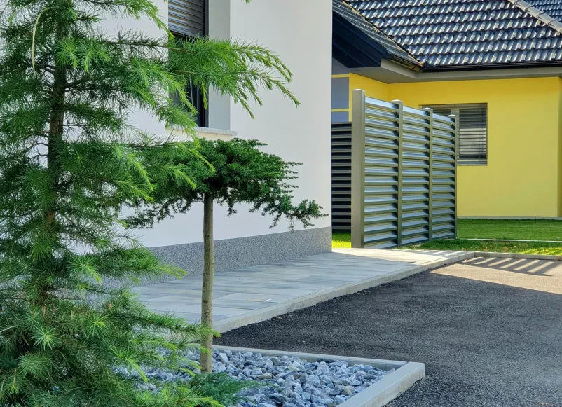Ekipno delo in sodelovanje v podjetju Impol Skupina treh sodelavcev, ki se osredotočeno pogovarja in sodeluje pri reševanju projektnih nalog v pisarni.