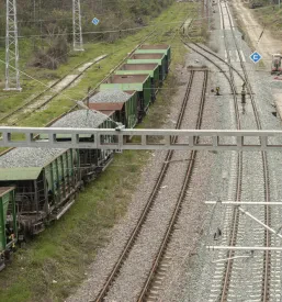 Povišan pogled na stare in nove železniške proge. Tovorni vagoni z gramozom podpirajo modernizacijo železniške infrastrukture.
