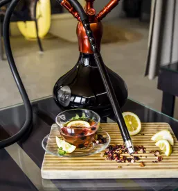 Šišo in čajna slovesnost z limono in meto na leseni deski. To je odličen dodatek ponudbi, ki jo ima Shisha in kava bar Ljubljana Center.