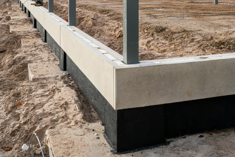 Betonski temelji novogradnje z jeklenimi stebri Temelji betonske novogradnje z jeklenimi stebri. Statični izračuni za novogradnje so ključni za stabilnost in varnost objekta.