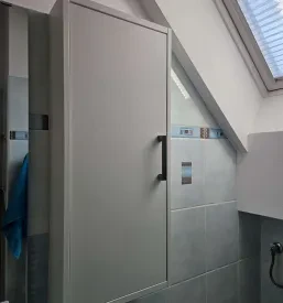 Celovit pogled na moderno urejeno kopalnico s čisto in funkcionalno sanitarno opremo. Kvalitetne strojne inštalacije.