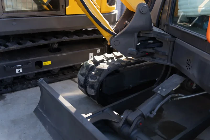 Komponente bagra z hidravlično roko Prikazane so komponente goseničnega bagra, vključno s hidravlično roko in dozer rezilom, v delovnem okolju. Kakovosten servis mini bagrov Goriška, Slovenija je ključnega pomena za vzdrževanje.
