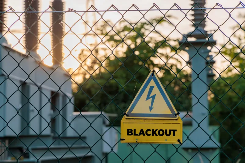 Opozorilni znak na ograji transformatorske postaje Opozorilni znak za električno nevarnost na ograji pred transformatorsko postajo ob sončnem zahodu, ki je ključna točka za dobavitelje električne energije v Ljubljani.