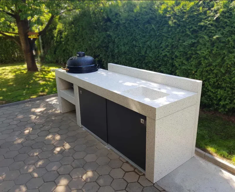 Moderna letna kuhinja z betonskim pultom Elegantna letna kuhinja z betonskim pultom, popolna za uživanje na prostem. Prikazuje vrhunsko Izdelavo in montažo betonskih komponent za dvorišča Slovenija.