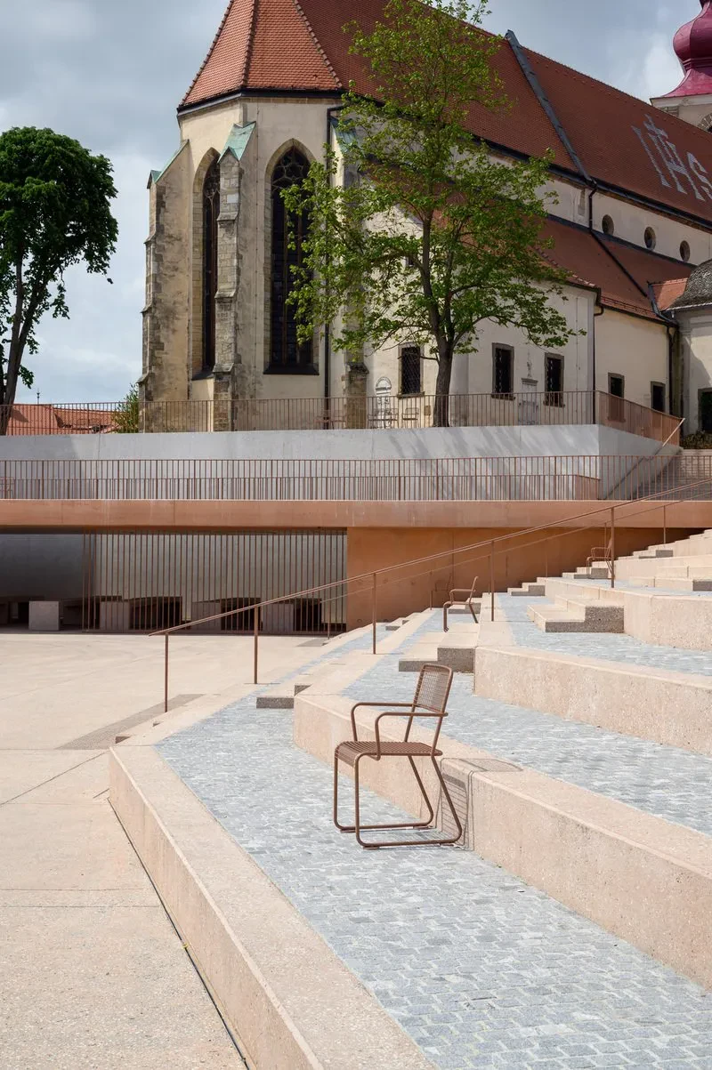 Ženska na elegantnih betonskih stopnicah Ženska se sprehaja po modernih zunanjih betonskih stopnicah. Ta Izdelava in montaža betonskih komponent za dvorišča Slovenija zagotavlja trajnost in estetiko.