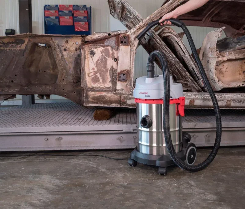Ženska čisti pisarniški hodnik Ženska z uporabo sesalnika čisti v industriji, kar poudarja pomen kvalitetne čistilne naprave in opreme za industrijo Slovenija.