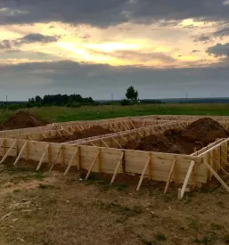 Leseni opaž za betonske pasovne temelje vikend hiše, postavljen na gradbišču. Takšen leseni opaž Selnica ob Dravi, okolica, zagotavlja trdno osnovo.